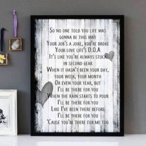 Framed wall art with black text of the song lyrics from I'll Be There For You by The Remembrandts, with a distressed wooden boards background.