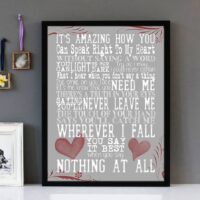 Framed wall art with white text of the song lyrics from When You Say Nothing At All by Ronan Keating, featuring red love hearts and a grey background.