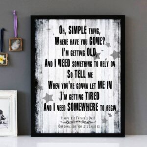 Framed wall art with black text of the song lyrics of Somewhere Only We Know by Keane, with a weathered floorboard background.