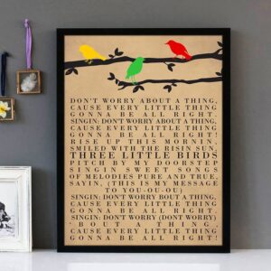 Framed wall art with black text of the song lyrics of Three Little Birds by the artist Bob Marley.